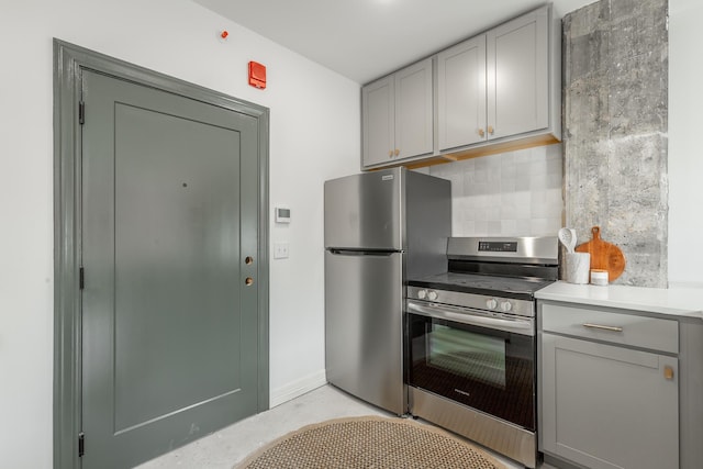 117 E 7th St Unit 302, Chattanooga, TN 37402 - kitchen featuring stainless steel appliances, gray cabinetry, backsplash, light countertops, and finished concrete floors