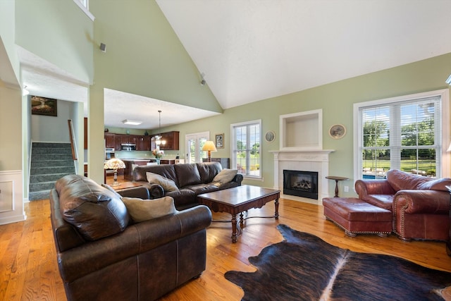 502 Tarver Ct, Smyrna, TN 37167 - living room with stairway, a fireplace with flush hearth, plenty of natural light, light wood finished floors, and high vaulted ceiling