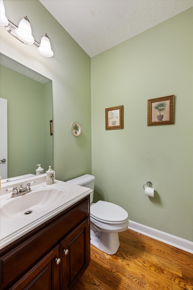 502 Tarver Ct, Smyrna, TN 37167 - bathroom with vanity, toilet, wood finished floors, a textured ceiling, and baseboards