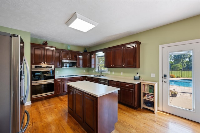 502 Tarver Ct, Smyrna, TN 37167 - kitchen with stainless steel appliances, a sink, light countertops, light wood-type flooring, and a kitchen island