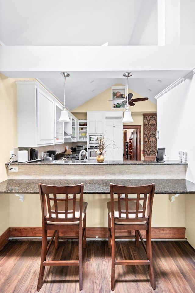 802 N 16th St, Nashville, TN 37206 - kitchen featuring oven, wood finished floors, vaulted ceiling, and a peninsula