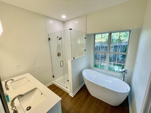 808 Split Oak Ct, Antioch, TN 37013 - bathroom featuring wood finished floors, a shower stall, a freestanding bath, double vanity, and baseboards