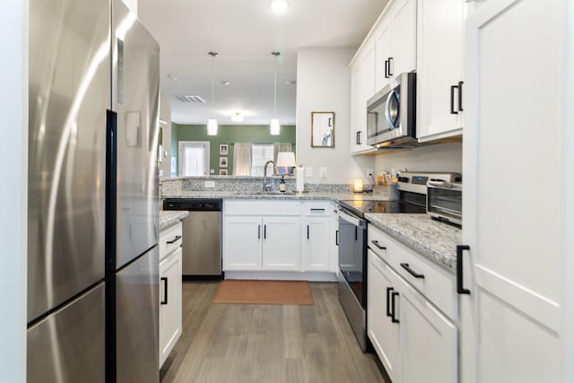 2515 Hanford Ave, Old Hickory, TN 37138 - kitchen featuring stainless steel appliances, a sink, white cabinetry, dark wood-style floors, and decorative light fixtures