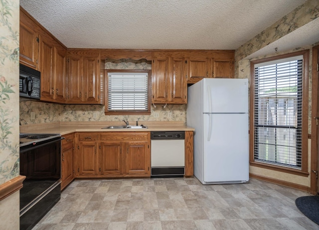 936 E Northfield Blvd, Murfreesboro, TN 37130 - kitchen featuring black appliances, a sink, brown cabinetry, light countertops, and a textured ceiling