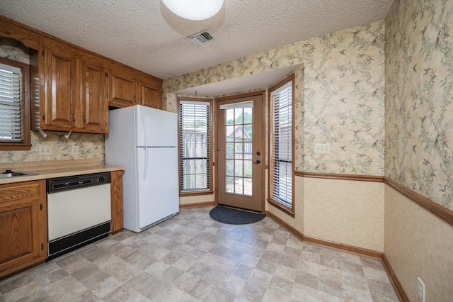 936 E Northfield Blvd, Murfreesboro, TN 37130 - kitchen featuring white appliances, light countertops, brown cabinets, wallpapered walls, and baseboards