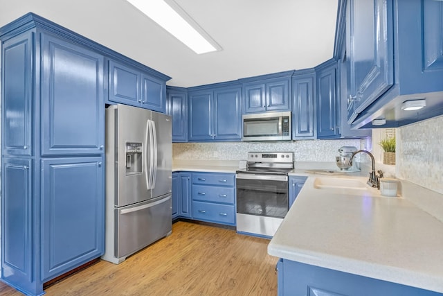 8801 Cedar Grove Rd, Cross Plains, TN 37049 - kitchen with stainless steel appliances, blue cabinets, a sink, light wood-style flooring, and light countertops