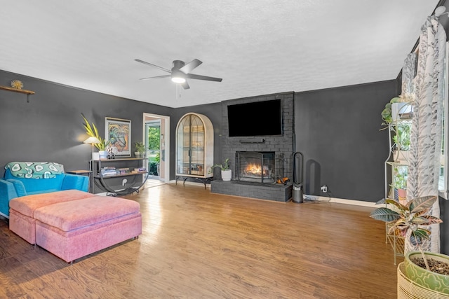 8801 Cedar Grove Rd, Cross Plains, TN 37049 - living area with ceiling fan, wood finished floors, a brick fireplace, a textured ceiling, and baseboards