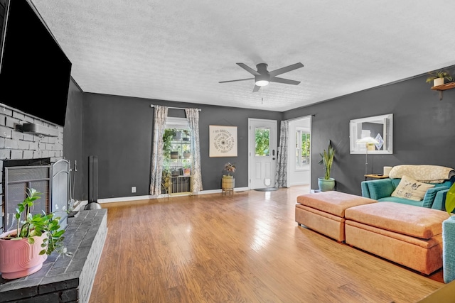 8801 Cedar Grove Rd, Cross Plains, TN 37049 - living area with ceiling fan, a brick fireplace, wood finished floors, a textured ceiling, and baseboards