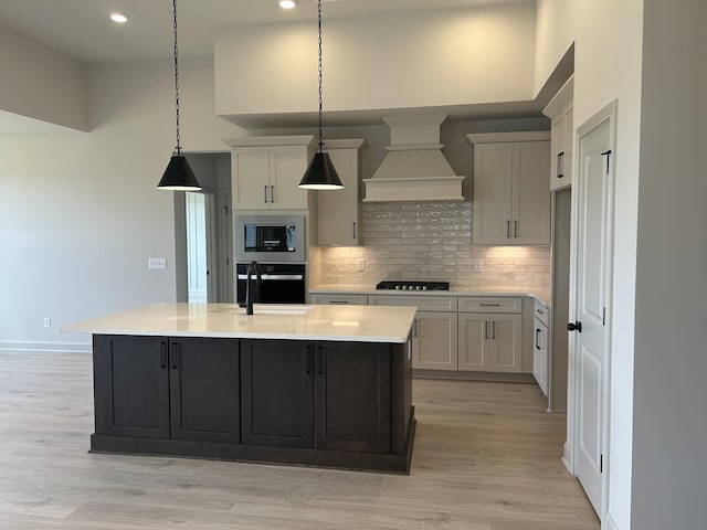 5416 Bridgemore Blvd, Murfreesboro, TN 37129 - kitchen with black oven, premium range hood, stainless steel microwave, light countertops, and decorative backsplash