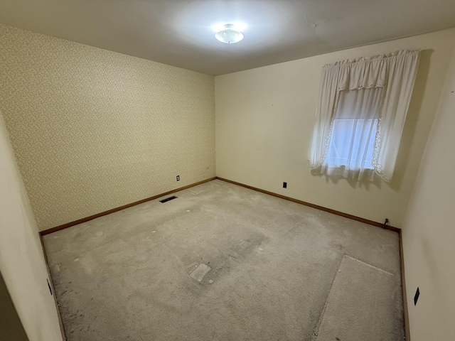 563 Ashe Ave, New Johnsonville, TN 37134 - empty room with baseboards, wallpapered walls, and light colored carpet