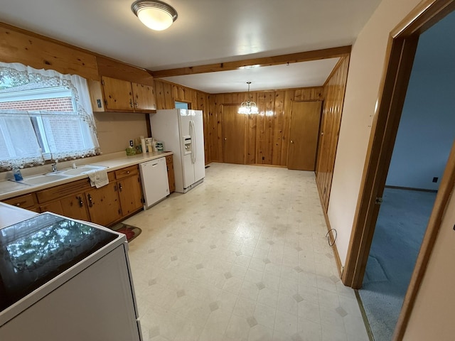 563 Ashe Ave, New Johnsonville, TN 37134 - kitchen with white appliances, a sink, wooden walls, light countertops, and brown cabinets