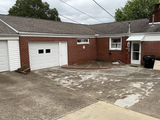 563 Ashe Ave, New Johnsonville, TN 37134 - view of side of home featuring brick siding, a shingled roof, driveway, and a garage