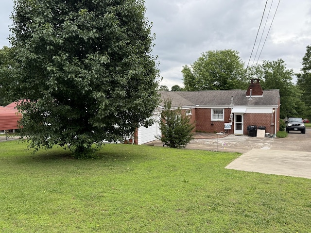 563 Ashe Ave, New Johnsonville, TN 37134 - rear view of house with brick siding, a yard, a chimney, and an attached garage