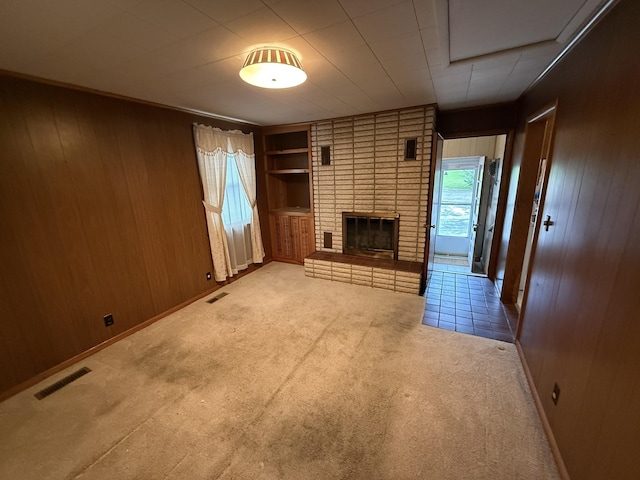 563 Ashe Ave, New Johnsonville, TN 37134 - unfurnished living room with wood walls, carpet flooring, a brick fireplace, and built in features
