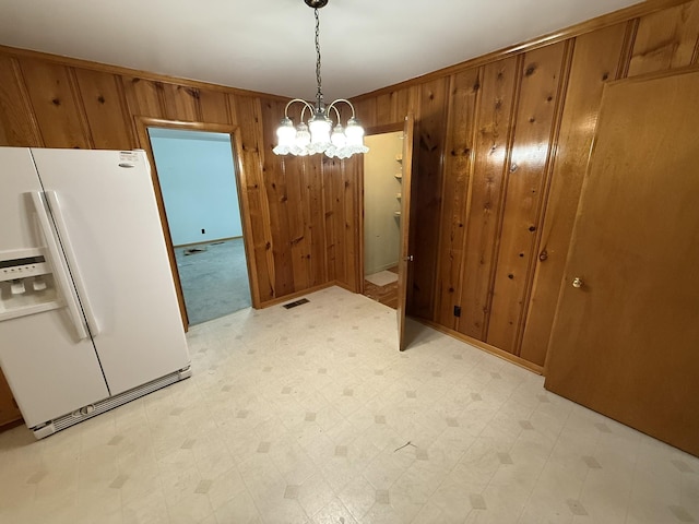 563 Ashe Ave, New Johnsonville, TN 37134 - unfurnished dining area featuring wooden walls, light flooring, and a chandelier