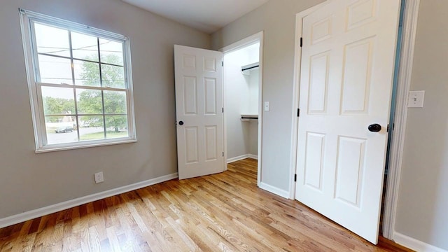 3012 Owendale Dr, Antioch, TN 37013 - unfurnished bedroom featuring multiple windows, light wood-style flooring, baseboards, and a walk in closet