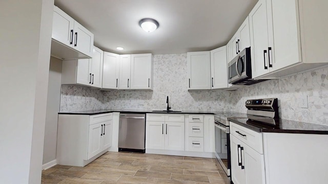 3012 Owendale Dr, Antioch, TN 37013 - kitchen featuring stainless steel appliances, a sink, dark countertops, backsplash, and light wood-style flooring