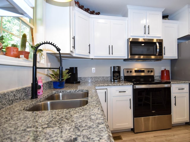 421 Marlin Ln, Westmoreland, TN 37186 - kitchen featuring appliances with stainless steel finishes, a sink, white cabinets, light stone counters, and light wood-style flooring