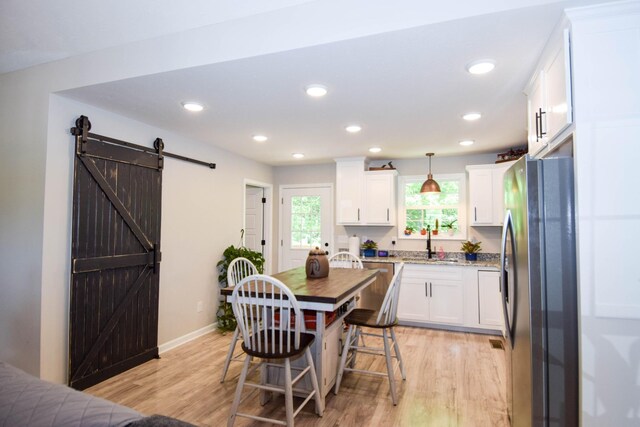 421 Marlin Ln, Westmoreland, TN 37186 - kitchen featuring freestanding refrigerator, a barn door, light wood-style floors, white cabinetry, and recessed lighting