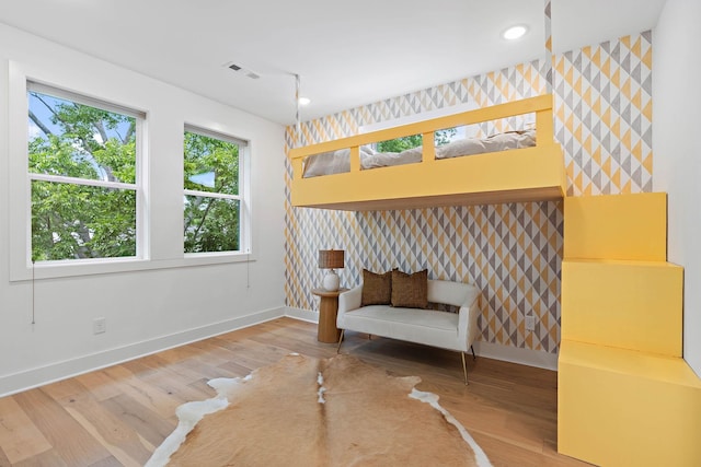 1003 Alice St Unit B, Nashville, TN 37218 - bedroom with wallpapered walls, baseboards, an accent wall, wood finished floors, and recessed lighting