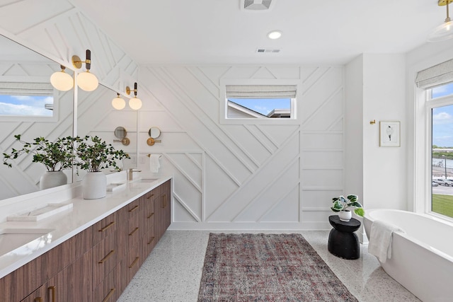 1003 Alice St Unit B, Nashville, TN 37218 - bathroom featuring speckle patterned floor, double vanity, a freestanding bath, a decorative wall, and baseboards