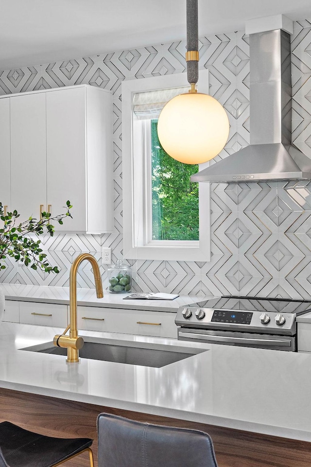 1003 Alice St Unit B, Nashville, TN 37218 - kitchen with wall chimney exhaust hood, stainless steel range with electric cooktop, decorative backsplash, white cabinetry, and light countertops
