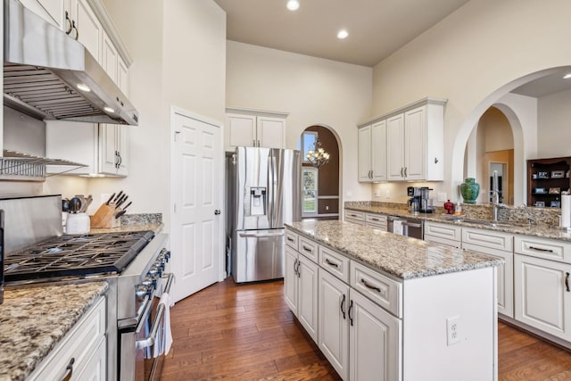 3820 Leona Pass, Hermitage, TN 37076 - kitchen featuring appliances with stainless steel finishes, under cabinet range hood, a kitchen island, white cabinets, and arched walkways