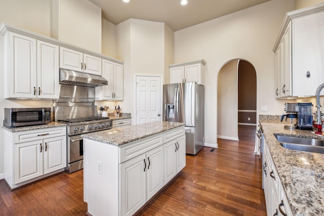 3820 Leona Pass, Hermitage, TN 37076 - kitchen with appliances with stainless steel finishes, under cabinet range hood, a sink, arched walkways, and white cabinets