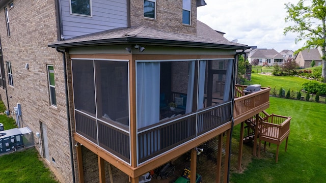 2816 Chatham Place Ct, Thompsons Station, TN 37179 - view of side of property featuring a sunroom, roof with shingles, a wooden deck, a yard, and brick siding