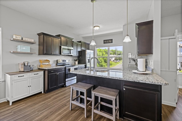 305 Jerry Butler Dr, La Vergne, TN 37086 - kitchen with appliances with stainless steel finishes, a sink, dark brown cabinetry, dark wood finished floors, and light stone counters
