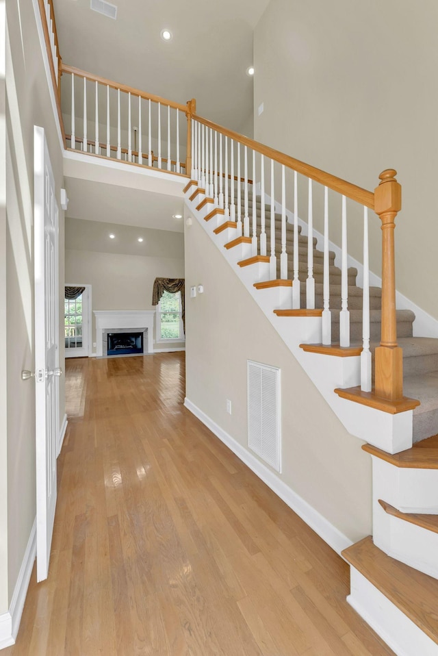411 Royal Xing, Franklin, TN 37064 - stairs with wood finished floors, a towering ceiling, a fireplace, baseboards, and recessed lighting