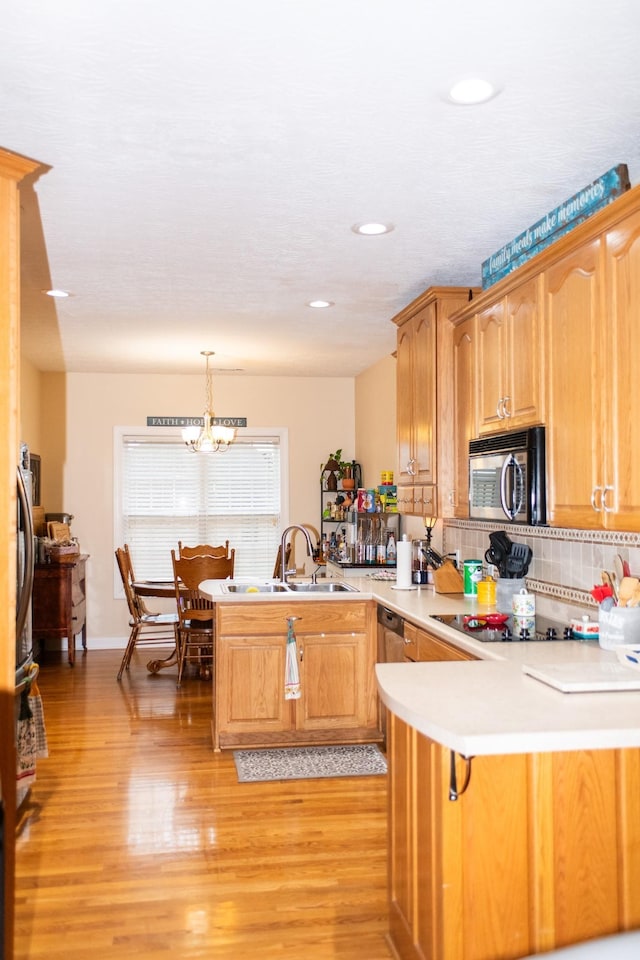 1005 Goldfinch Trl, Portland, TN 37148 - kitchen featuring a peninsula, black appliances, a sink, a chandelier, and light wood-type flooring