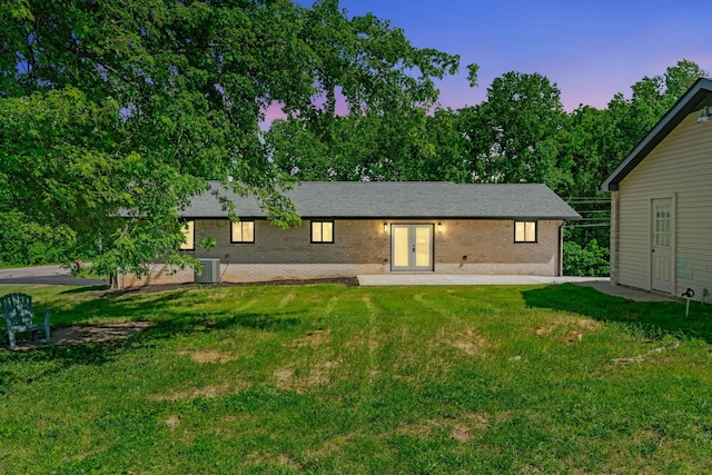 120 E Boiling Springs Rd E, Portland, TN 37148 - back of property at dusk featuring french doors, a yard, central AC unit, and brick siding