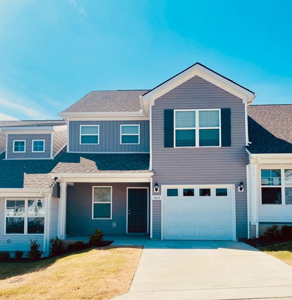 676 Hamilton Crossings, Antioch, TN 37013 - view of front of property featuring concrete driveway, a front yard, an attached garage, board and batten siding, and roof with shingles