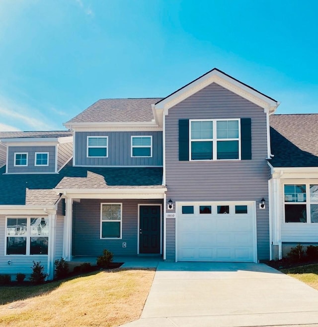 676 Hamilton Crossings, Antioch, TN 37013 - view of front of property featuring concrete driveway, a front yard, an attached garage, board and batten siding, and roof with shingles
