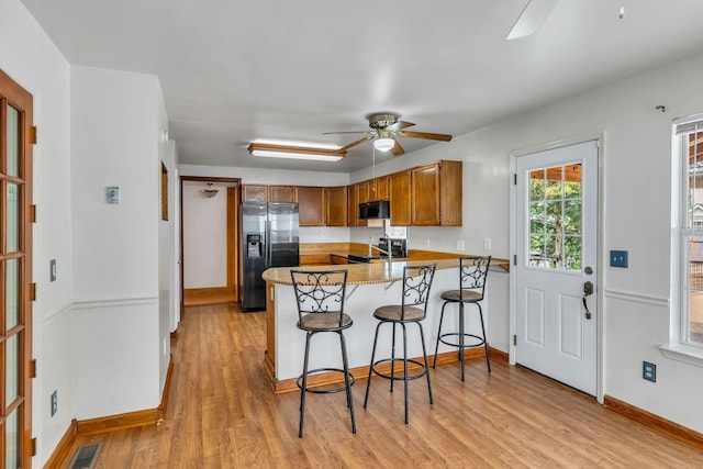 1510 Walnut Hills Dr, Chapel Hill, TN 37034 - kitchen with stainless steel fridge with ice dispenser, a peninsula, ceiling fan, black microwave, and brown cabinetry