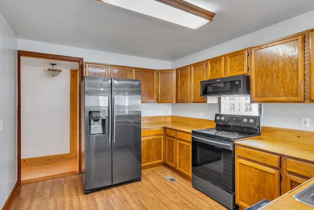 1510 Walnut Hills Dr, Chapel Hill, TN 37034 - kitchen featuring stainless steel appliances, light wood-style floors, light countertops, and brown cabinetry