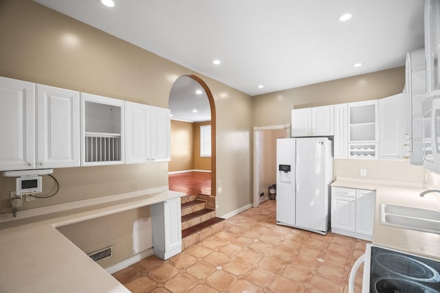 723 Vanderhorst Dr, Nashville, TN 37207 - kitchen with white appliances, arched walkways, white cabinets, a sink, and recessed lighting