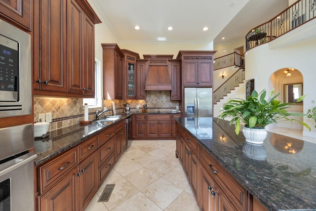 891 Fairington Pvt Way, Gallatin, TN 37066 - kitchen featuring appliances with stainless steel finishes, custom range hood, tasteful backsplash, a sink, and glass insert cabinets
