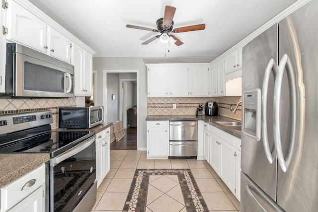 1012 Blue Ridge Pkwy, Goodlettsville, TN 37072 - kitchen with appliances with stainless steel finishes, a sink, backsplash, and white cabinetry