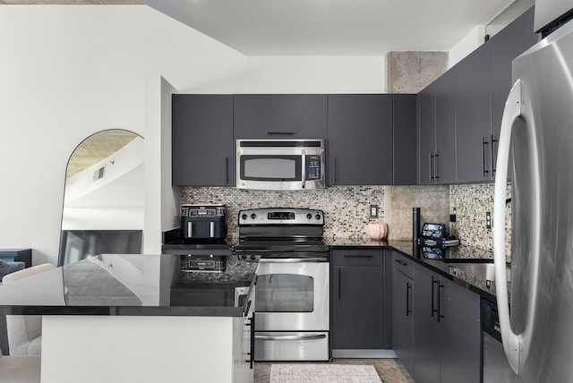 600 12th Ave S Unit 1208, Nashville, TN 37203 - kitchen featuring appliances with stainless steel finishes, decorative backsplash, dark stone counters, and open floor plan