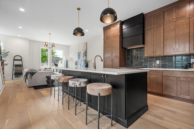 6104 Cowden Ave Unit A, Nashville, TN 37209 - kitchen with light wood finished floors, light countertops, tasteful backsplash, a kitchen island with sink, and recessed lighting