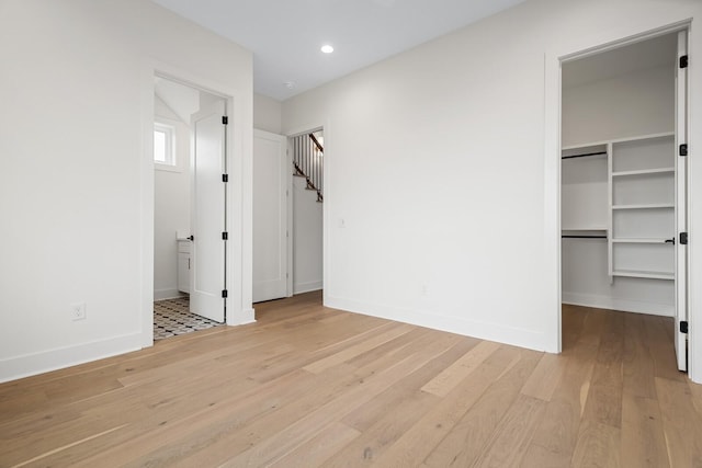 6104 Cowden Ave Unit A, Nashville, TN 37209 - unfurnished bedroom with wood finished floors, a walk in closet, baseboards, recessed lighting, and connected bathroom