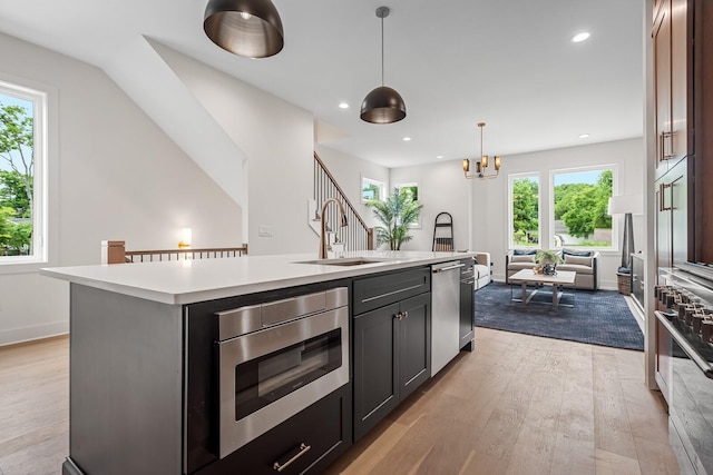 6104 Cowden Ave Unit A, Nashville, TN 37209 - kitchen featuring a sink, light countertops, stainless steel appliances, a kitchen island with sink, and light wood finished floors