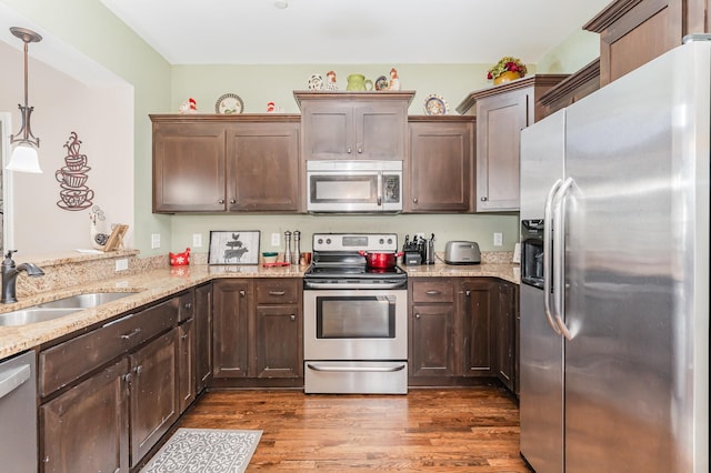 1026 Grace Meade, Ashland City, TN 37015 - kitchen featuring stainless steel appliances, a sink, dark wood-style floors, light stone countertops, and dark brown cabinets