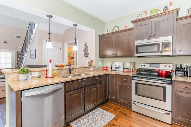 1026 Grace Meade, Ashland City, TN 37015 - kitchen with stainless steel appliances, a sink, a peninsula, wood finished floors, and dark brown cabinets