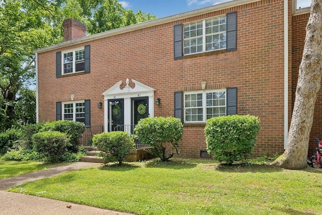 601 Boyd Mill Ave Unit A2, Franklin, TN 37064 - colonial-style house featuring a chimney, a front yard, and brick siding