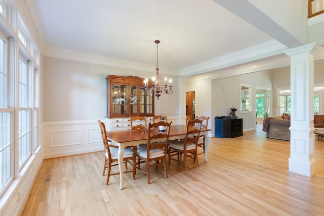 205 Saint Anne Way, Franklin, TN 37064 - dining room featuring ornate columns, light wood-type flooring, a chandelier, ornamental molding, and wainscoting