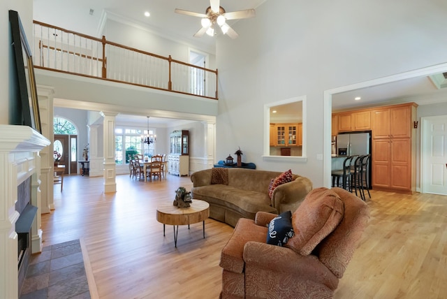 205 Saint Anne Way, Franklin, TN 37064 - living area featuring ornate columns, a ceiling fan, a high ceiling, light wood-type flooring, and a chandelier