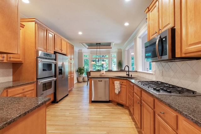 205 Saint Anne Way, Franklin, TN 37064 - kitchen featuring appliances with stainless steel finishes, a sink, light wood-style floors, dark stone counters, and recessed lighting